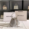 Silver crystal-embellished evening clutch with chain displayed on a white surface.