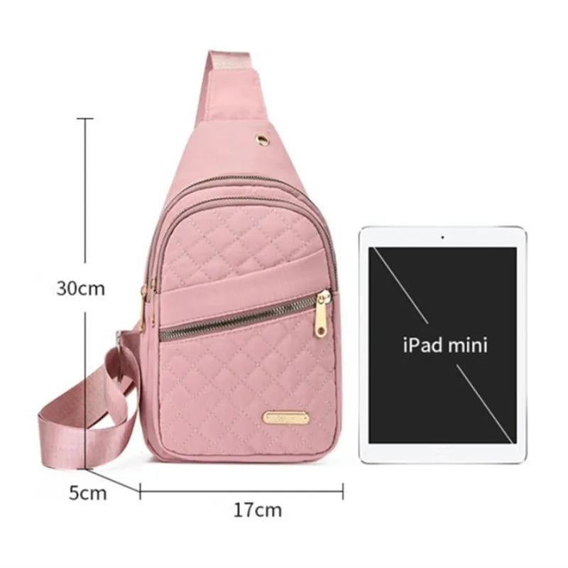 A pink quilted crossbody sling bag is shown next to an iPad mini for scale.