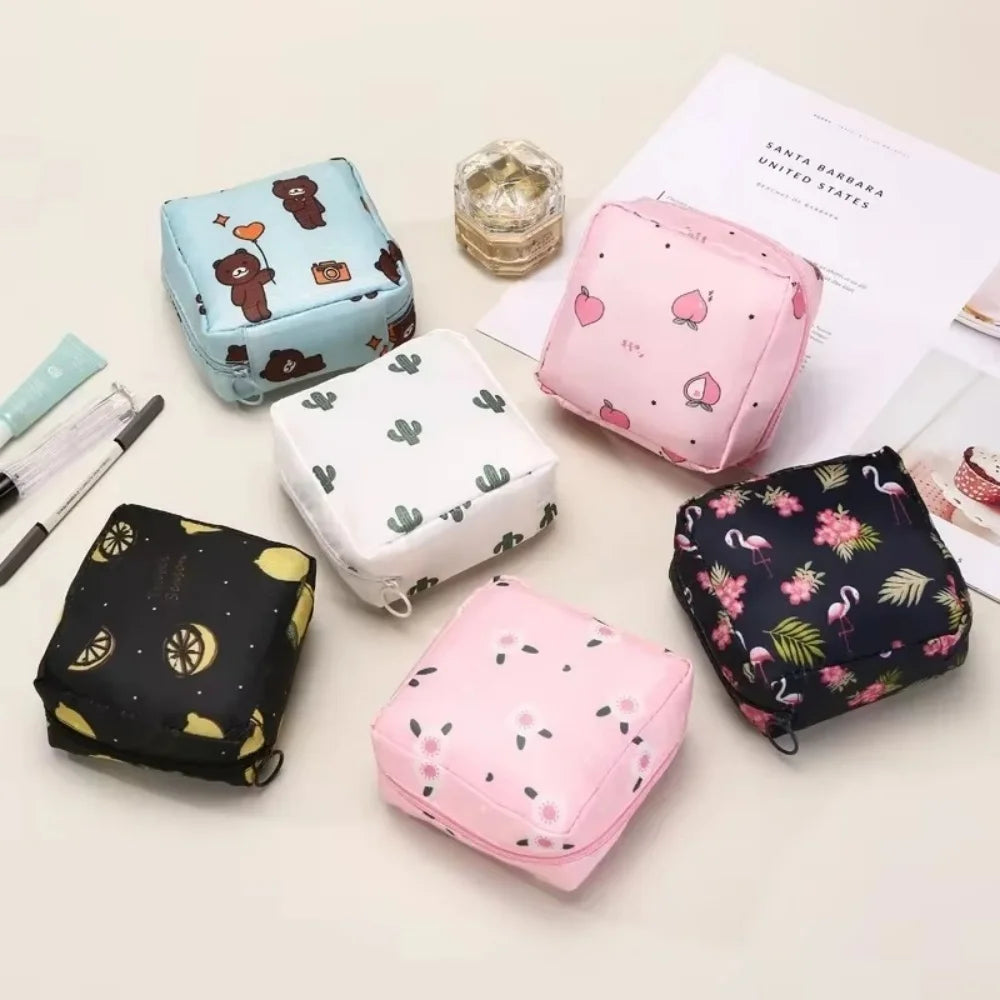 A collection of pink and blue portable waterproof sanitary napkin storage pouches displayed on a white surface.