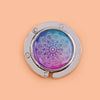 Silver folding table bag hook with a round glass featuring a purple and blue marble pattern