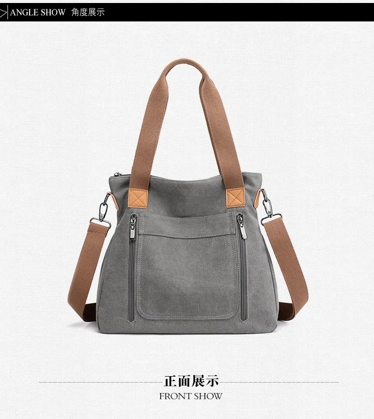 Front view of a gray canvas tote bag with brown leather straps.