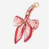 A red and white patterned fabric strap with a gold-toned clasp, designed as an adjustable bag strap.