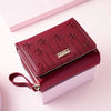 A deep red PU leather wallet with embossed floral patterns is shown open, resting on a white surface.