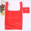A bright red eco-friendly foldable shopping bag next to a small red bag.