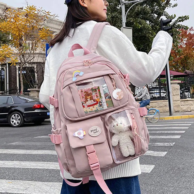 A woman wearing a pink backpack with various pouches and a fluffy white stuffed animal is walking outdoors.