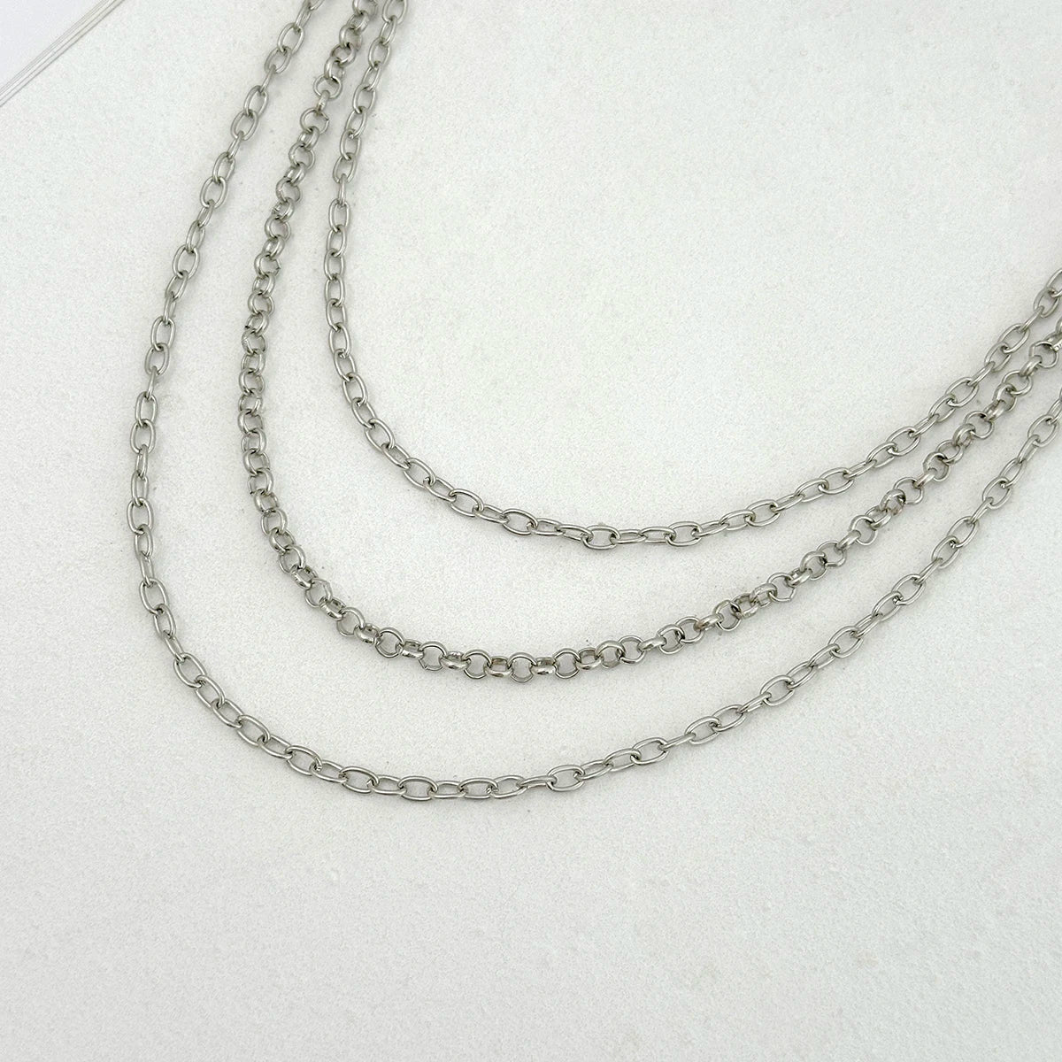 Silver punk star chain belt with pearl accents displayed on a white background.