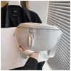 A hand holds a light gray women's PU leather crossbody saddle bag with a chain strap against a white box.