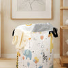A white canvas laundry and storage basket decorated with colorful animal illustrations.
