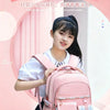 A young woman is holding a pink lightweight girl-style schoolbag against a light pink background.