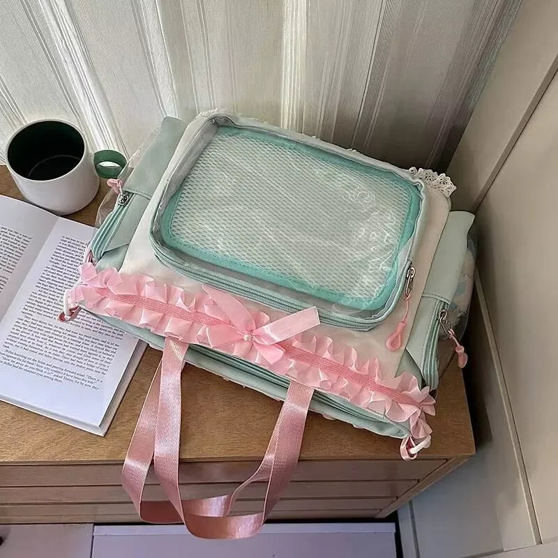 A light mint green transparent shoulder tote bag with pink trim resting on a wooden surface.