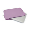 A purple multi-size laptop sleeve placed next to a silver laptop.