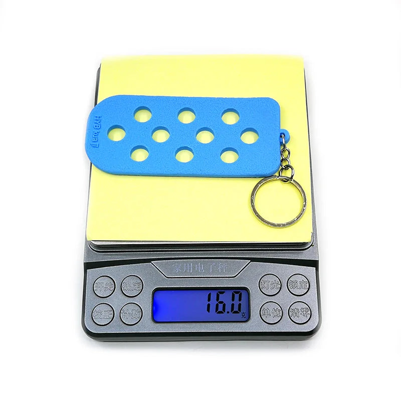 Un porte-clés avec un support de chaussure en silicone bleu dans une boîte en plastique jaune.