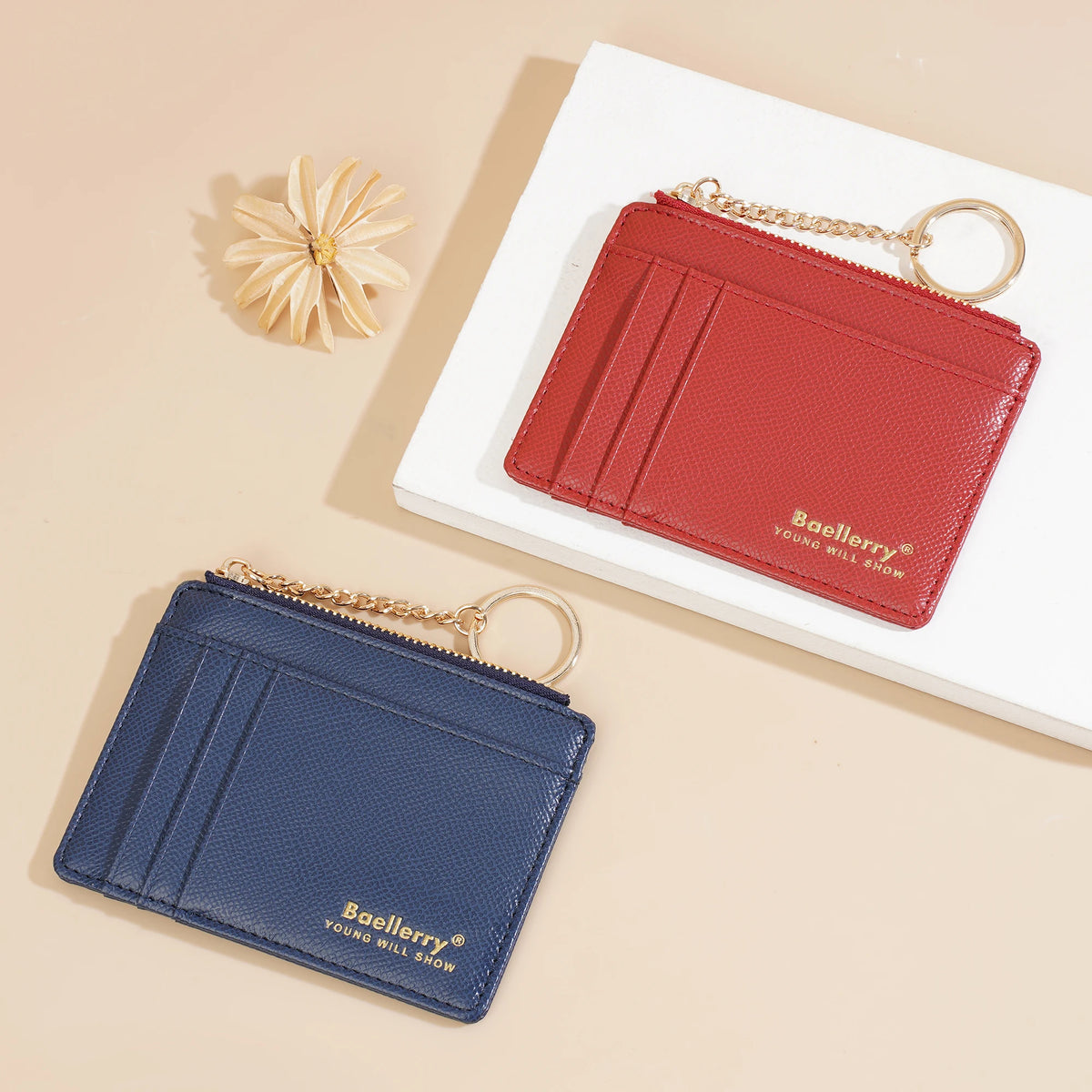 A red Baellerry card holder wallet with a gold chain is displayed next to a dark blue Baellerry wallet on a white background.