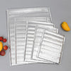 Stack of silver aluminum foil insulated thermal food delivery bags with a yellow fruit.
