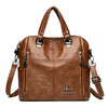 A brown leather fashion crossbody backpack bag with silver hardware.
