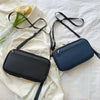 A navy blue multi-pocket travel document organizer bag with black straps lying on a white fabric background.