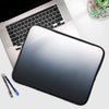 A silver laptop is shown with a black multi-size sleeve placed in front of it, next to a pen.