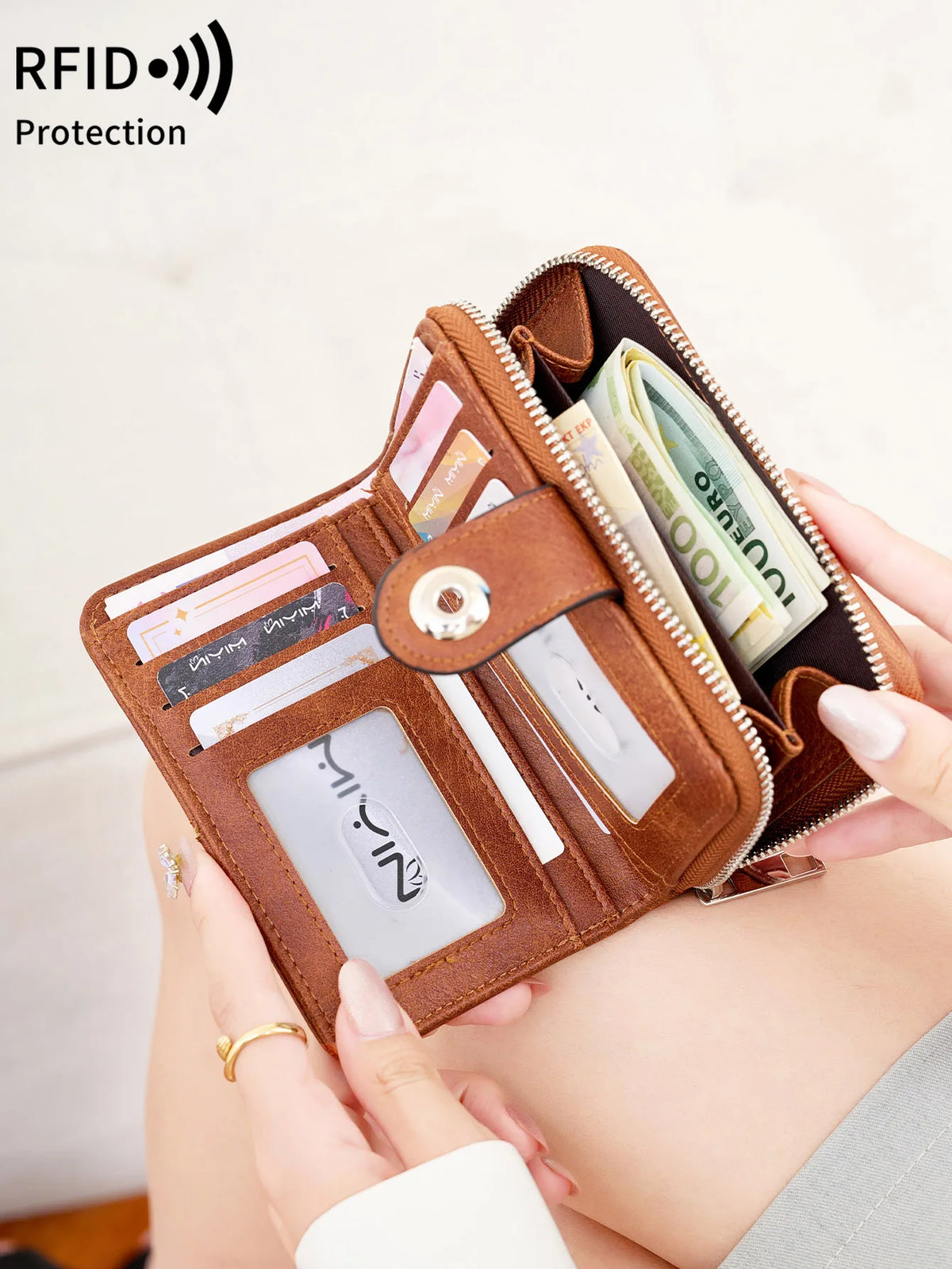 A close-up of a brown leather RFID blocking multi-function women's wallet with various cards and cash inside.