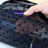 A hand is opening a black mesh transparent makeup storage bag, revealing a purple glow inside.