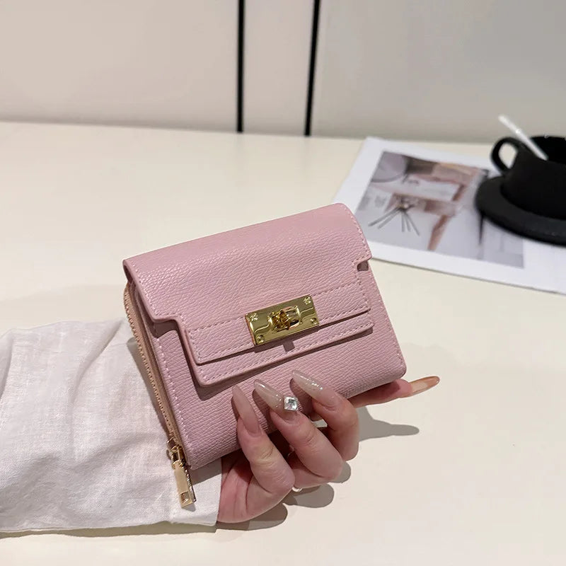 A pink multi-slot card holder is held in a hand against a white background.