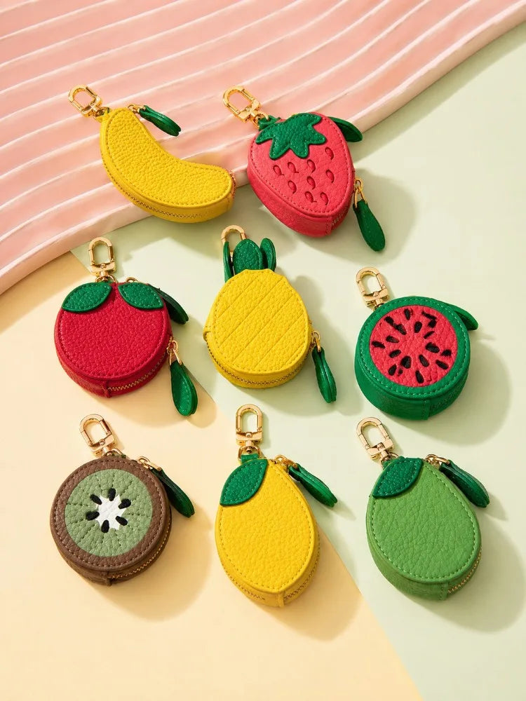 A collection of fruit-shaped PU leather coin purse keychains in red, yellow, and green colors.