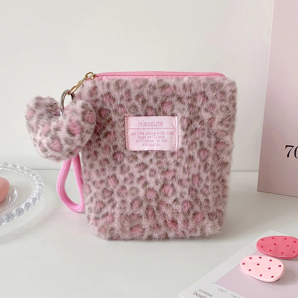 A fluffy pink leopard print makeup bag with a gold zipper and pink strap.