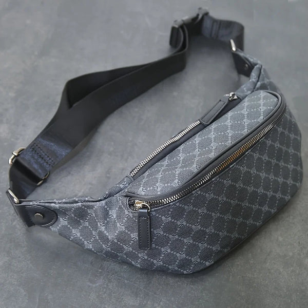 A dark gray patterned designer waist bag with a black strap is shown against a gray background.
