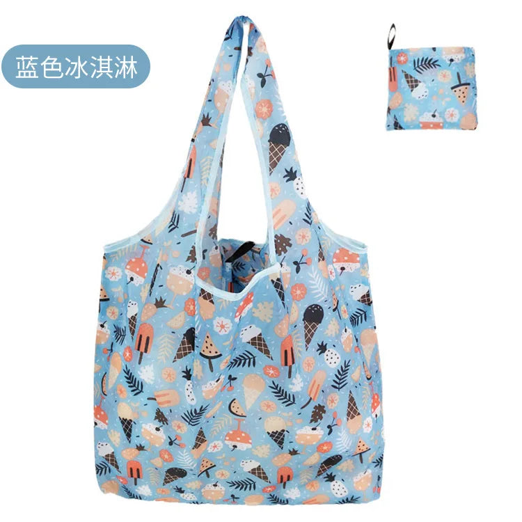 A light blue reusable eco tote shopping bag featuring a pattern of various fruits and leaves.