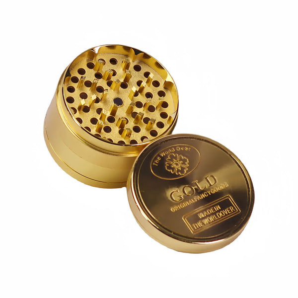 A gold coin pattern metal grinder with a brass body and a perforated top view.