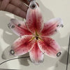 A realistic pink and red orchid flower keychain is being held by a hand.