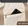 A beige quilted nylon travel duffle bag showing a rear zippered pocket.