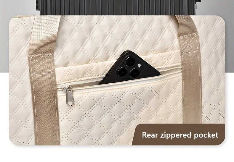 A beige quilted nylon travel duffle bag showing a rear zippered pocket.