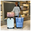 Une femme se tient à côté d'une pochette de voyage multi-usage bleu clair extensible et d'une valise rose dans un magasin mod