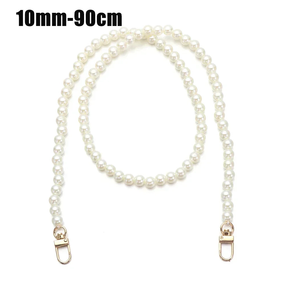 A strand of white pearls used as a strap for a handbag or purse.