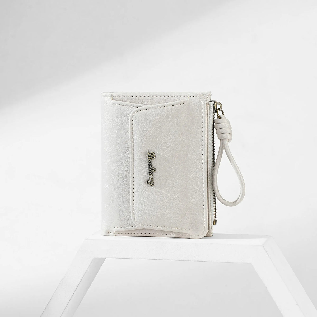 A white PU leather mini wallet with a silver pendant is shown resting on a white surface.