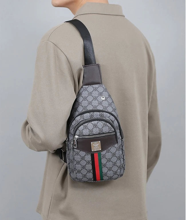 A man wears a beige shirt and a dark brown leather crossbody sling bag with a gray patterned fabric and green, red, and black
