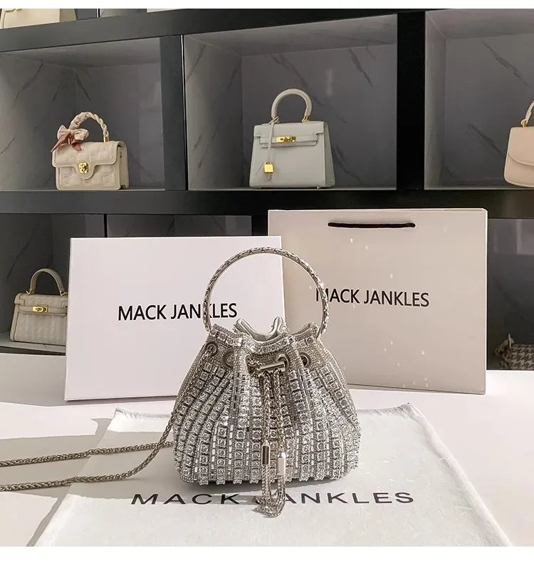 Silver crystal-embellished evening clutch with chain displayed on a white surface.