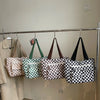 A display of various striped pattern corduroy tote bags hanging on a metal rack.
