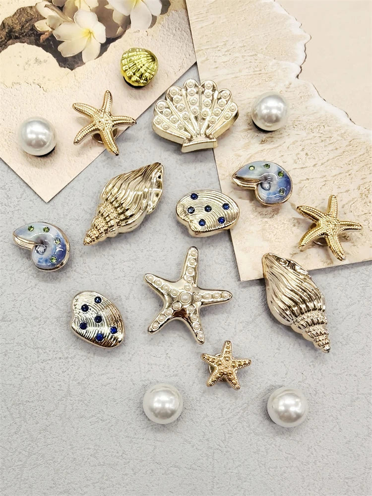 A collection of gold and silver conch shell shoe charms, including starfish, pearls, and various decorative shapes.