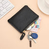 A black genuine leather mini zipper purse with a gold chain and attached keys
