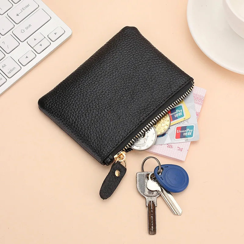 A black genuine leather mini zipper purse with a gold chain and attached keys