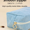 Light blue corduroy makeup organizer bag featuring a smooth zipper and a metal pull head.