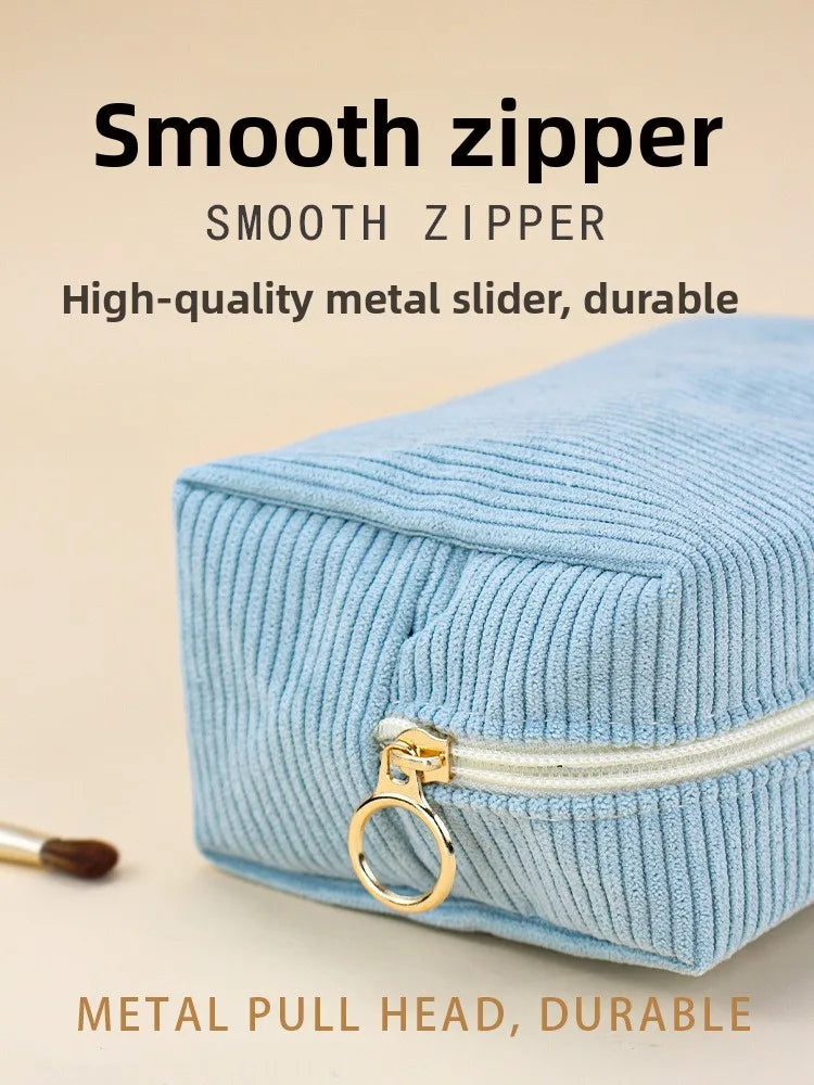 Light blue corduroy makeup organizer bag featuring a smooth zipper and a metal pull head.
