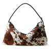 A brown and white spotted vintage horsehair and cowhide crossbody bag.