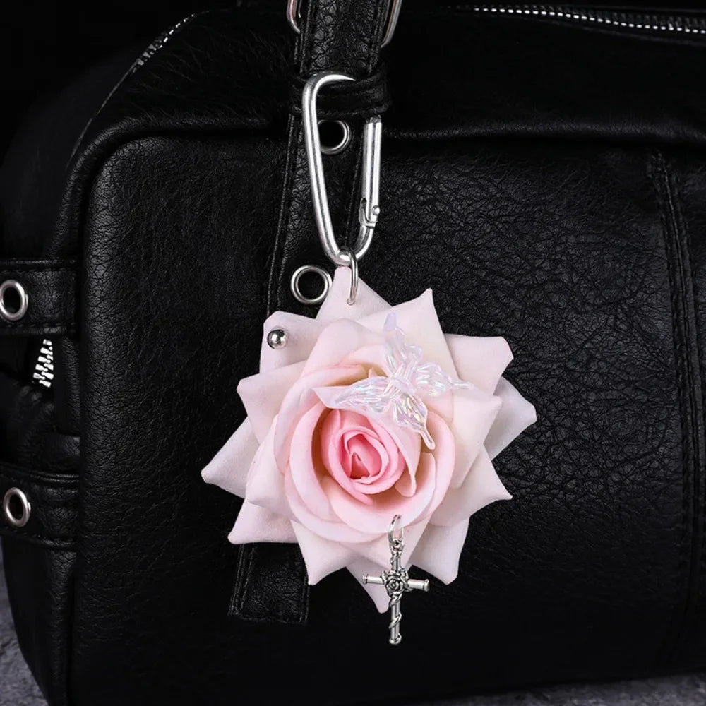 A realistic pink orchid flower keychain attached to a black leather handbag.