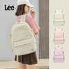 A young woman is wearing a beige Oxford school backpack from Lee, shown alongside pink and purple color variations.