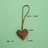 A brown PU leather heart-shaped keychain with a long loop, weighing 15 grams.