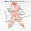 An adjustable diagonal shoulder strap in coral floral print shown on a white box.