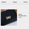 Aumento de detalle de una cartera de tarjeta de cuero PU negro plegable con logotipo trenzado dorado.