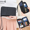 A black RFID blocking travel wallet is shown being held by a person, featuring a passport and other documents.